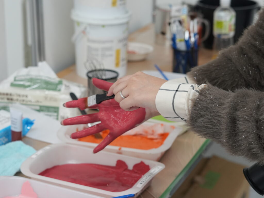 手にクレイペイントを塗っている