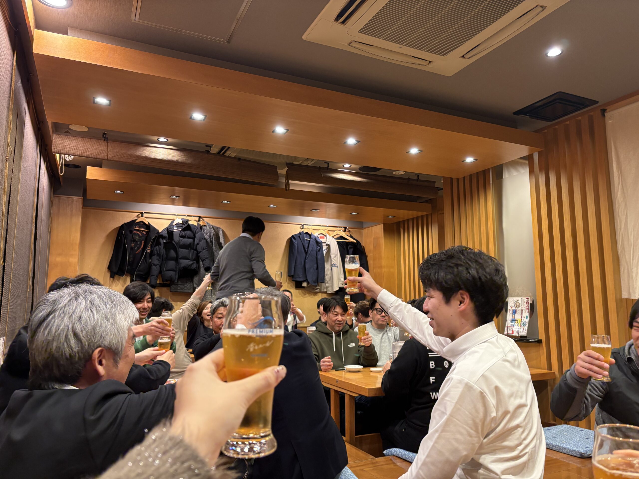 ボウリング大会後の懇親会で会社を越えて会話が弾む様子