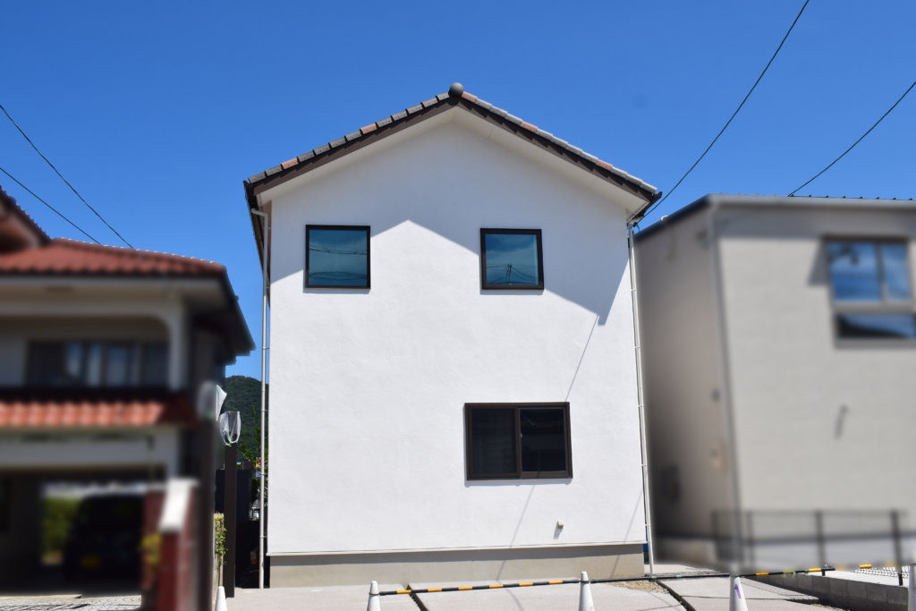 漆喰外壁と瓦屋根が特徴のナチュラルな2階建て住宅外観